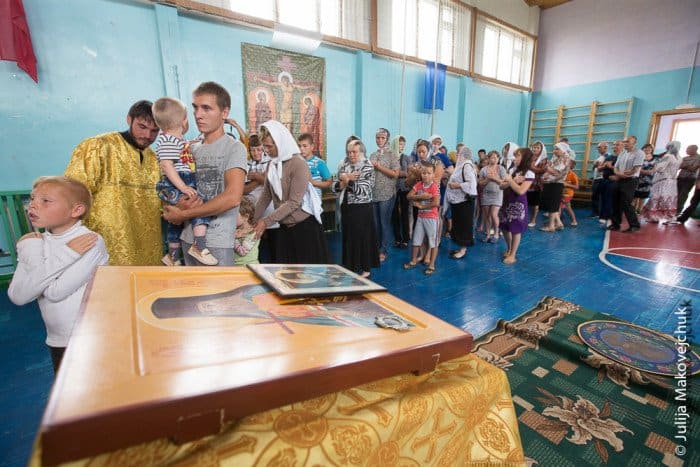 Сорок три новокрещеных христианина стоят в очереди к Чаше. В село Макарово мы прибыли вечером, время терять не стали и провели встречу-знакомство с жителями. На следующий день рано утром было крещение, а после отслужена литургия в самом большом помещении — спортивном зале школы-интерната 